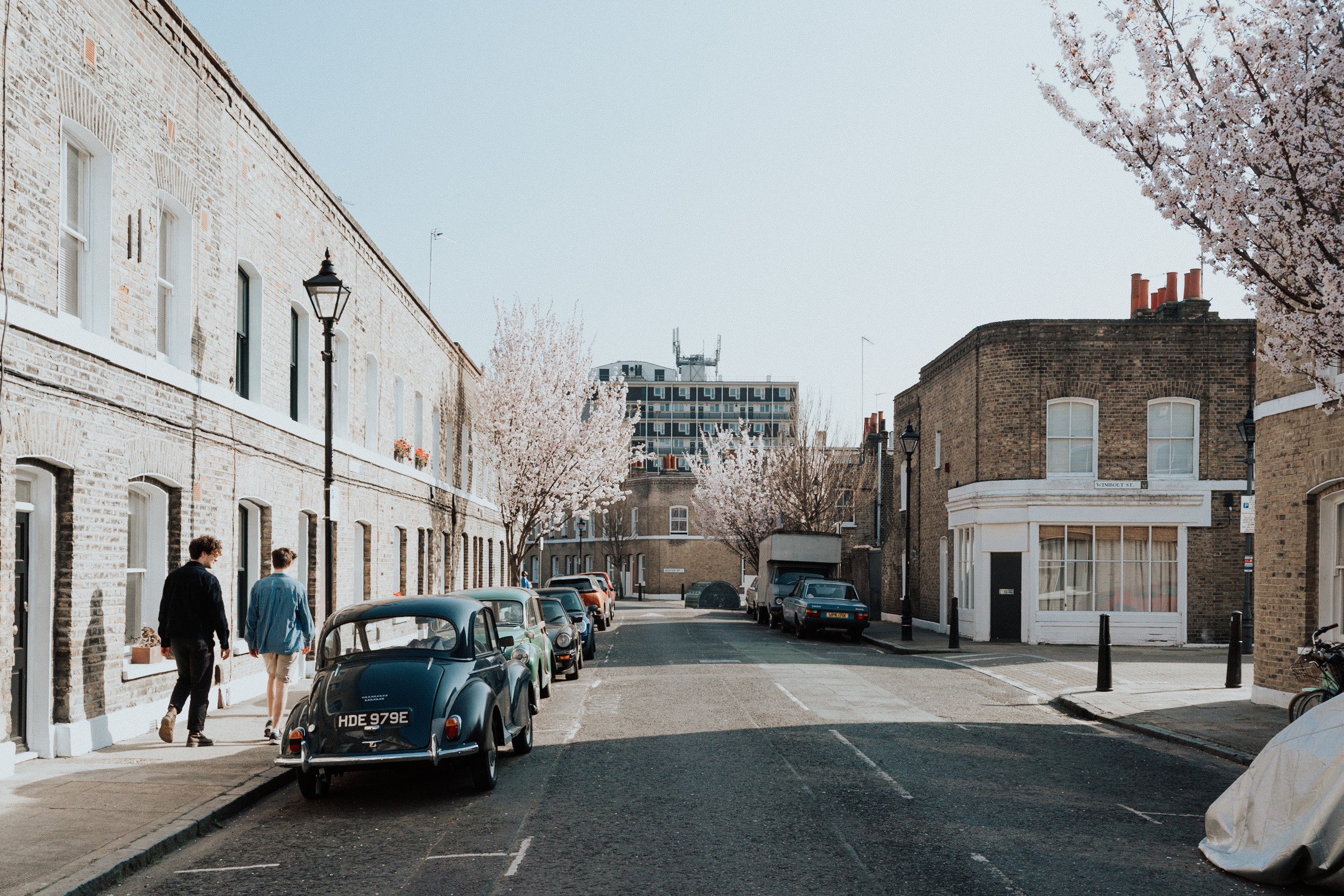 two boys walking down a street in east london