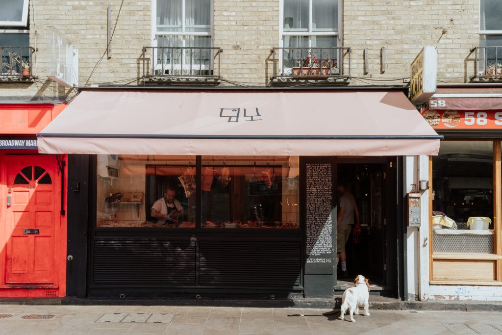 Business and emotion dog in front of butchers at Broadway Market in London