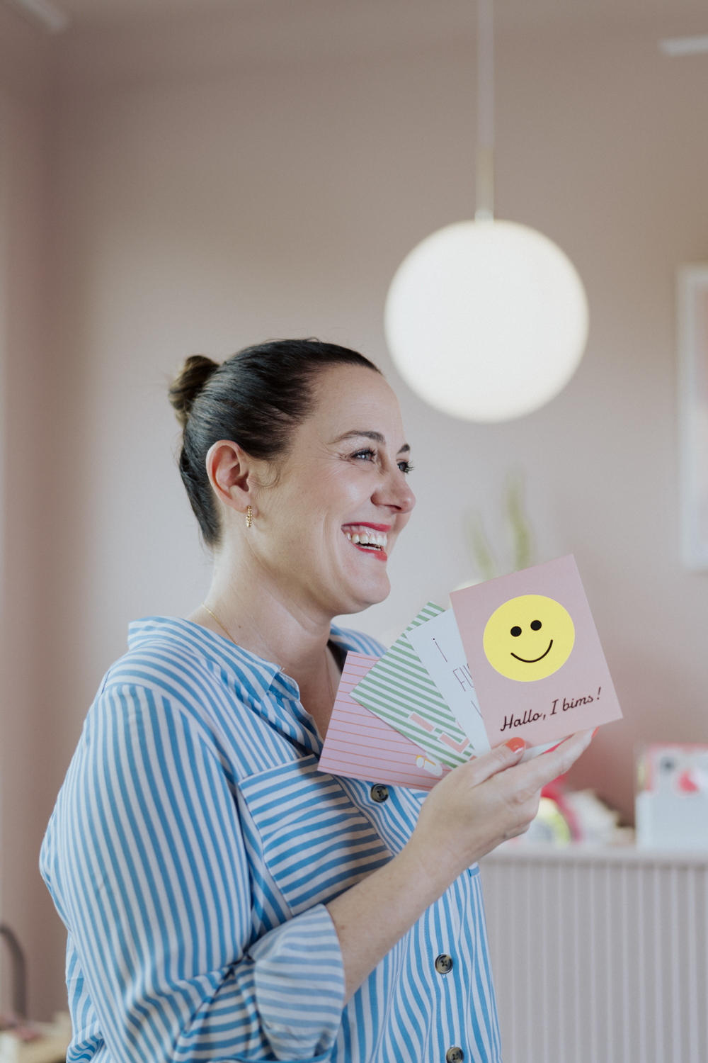 Lifestyle Portrait of a Designer laughing and holding her designs