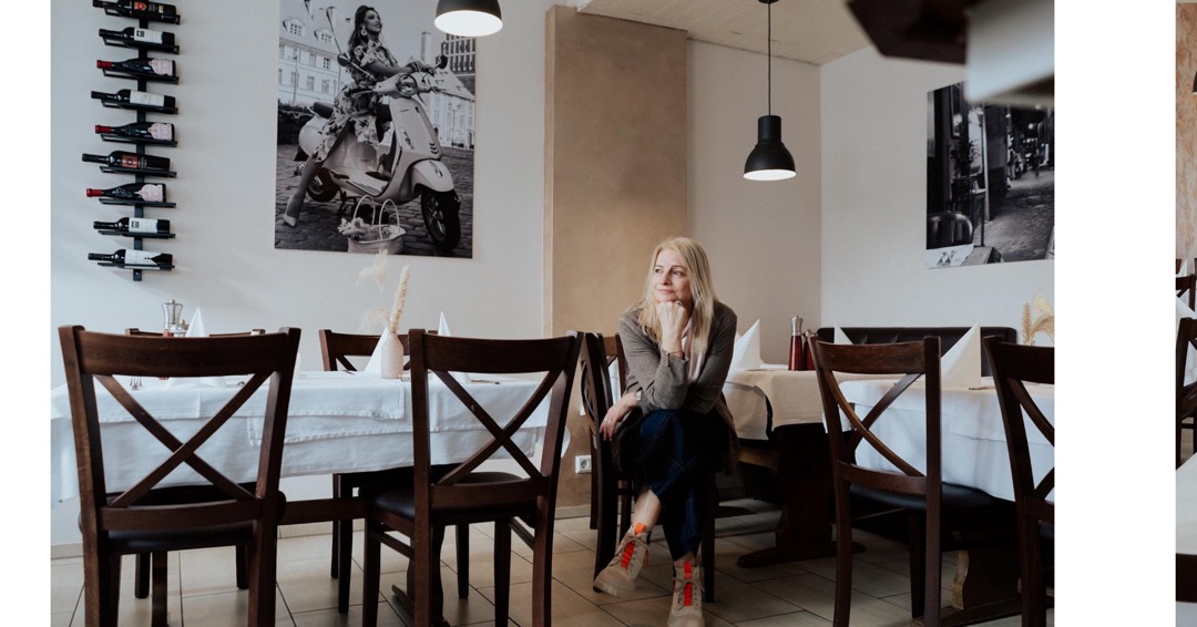 owner of the Ristorante Lichtenstein Reutlingen sitting between tables