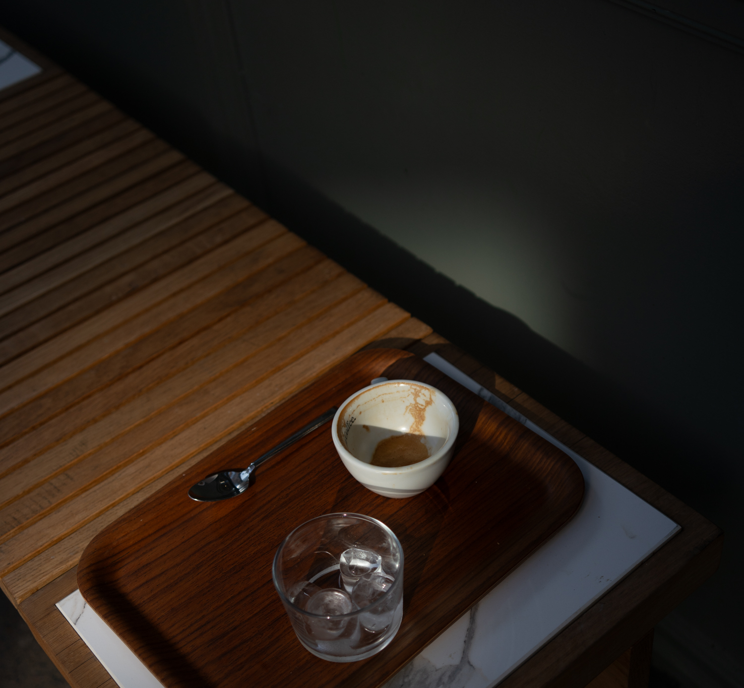 empty cup of coffee on a bench in the sun