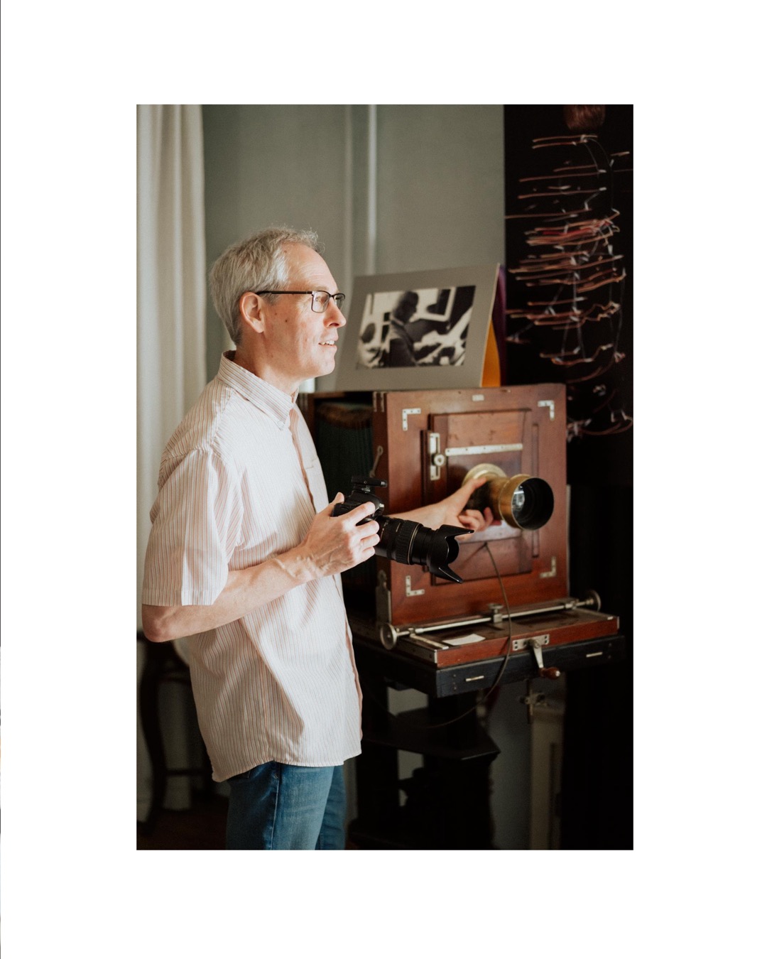 Photographer Steffen Burgermeister standing by a very old camera in his studio in Pfullingen, Photographer Steffen Burgemeister steht neben einer uralten Kamera in seinem Fotostudio in Pfullingen