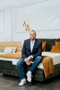Editorial Lifestyle Portrait of sleep expert Daniel Amann sitting on a bed in his shop