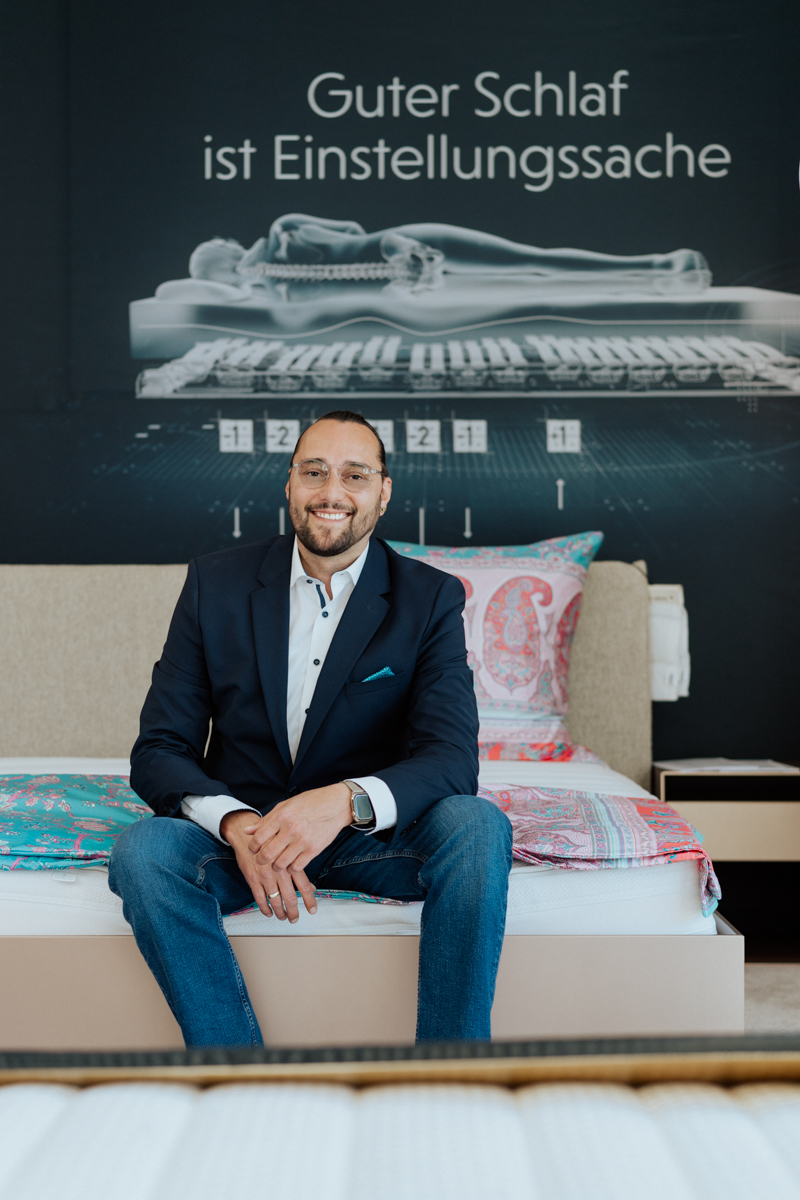 sleep expert Daniel Amann in his shop on a bed