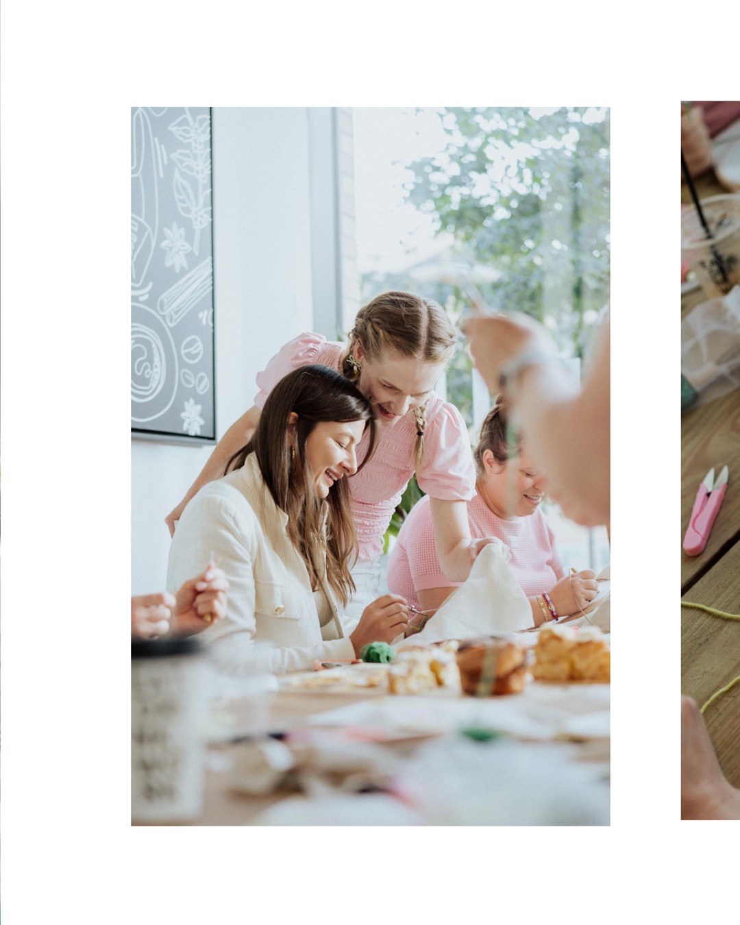 Maria Voropayeva leaning over a coffee shop table, gesturing with her hands while explaining punch needle embroidery to workshop attendees.