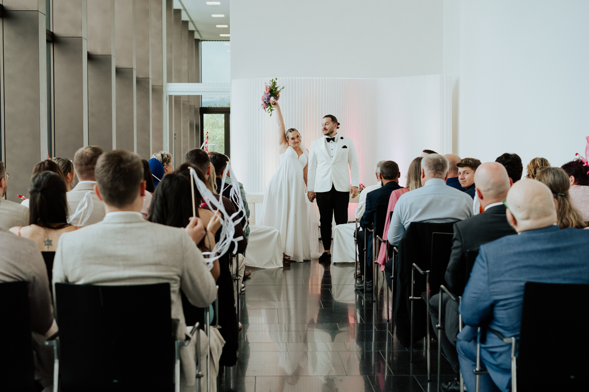 Bride raising her wedding bouquet after saying I do in Reutlingen / Braut streckt ihren Brautstrauß nach dem Ja-Wort jubelnd nach oben in Reutlingen
