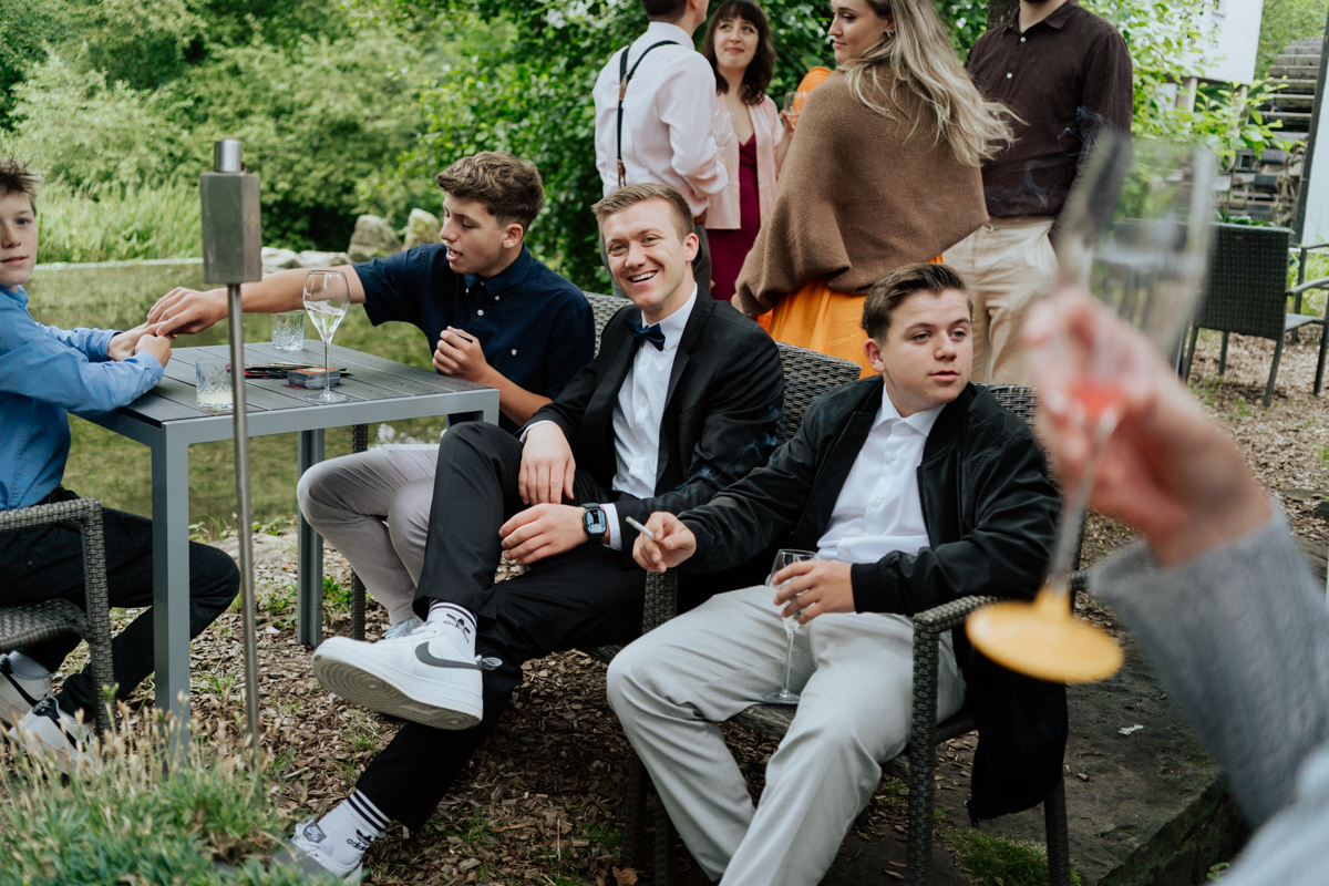Young teenage guests sitting together at wedding celebration in Reutlingen / Junge männliche Jugendliche sitzen zusammen bei der Hochzeitsfeier in Reutlingen