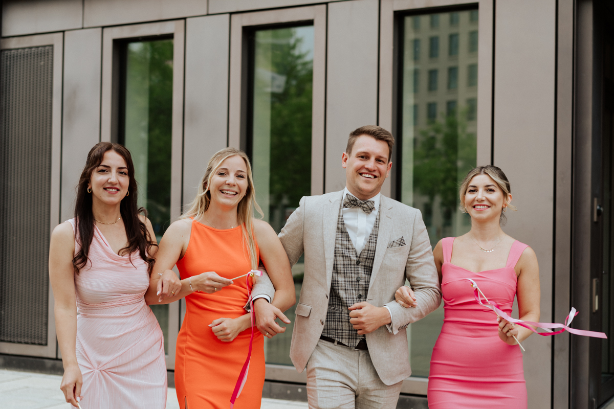 Colorful dressed friends of the bride and groom laughing together in Reutlingen / Freunde des Brautpaars in bunten Outfits lachen in die Kamera bei der Hochzeit Reutlingen