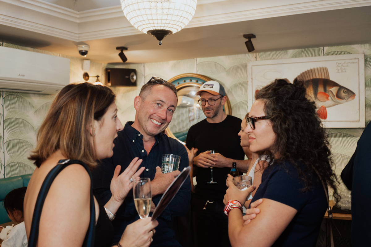 Guests socializing and sharing stories during a London anniversary party / Gäste unterhalten sich entspannt bei einem Jubiläum in London