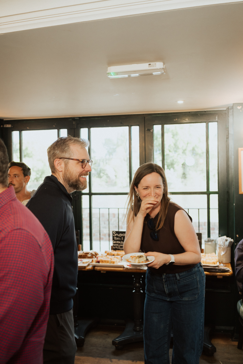 Two guests sharing a heartfelt laugh at an evening pub event in London / Zwei Gäste lachen herzhaft miteinander bei der Feier in London
